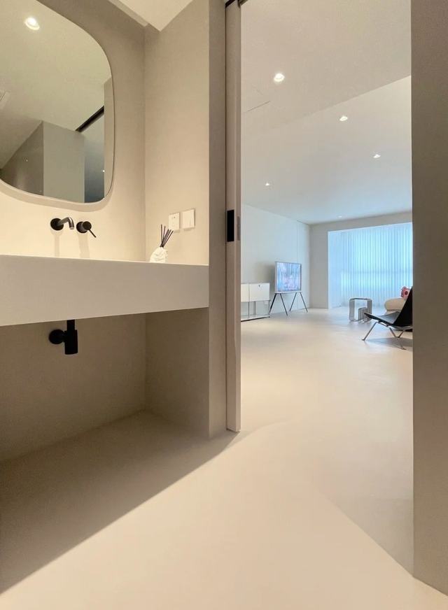Microcement vanity and floor running into the next room