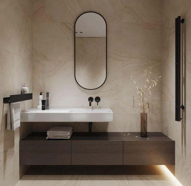 Dark vanity with lit plinth and oval mirror