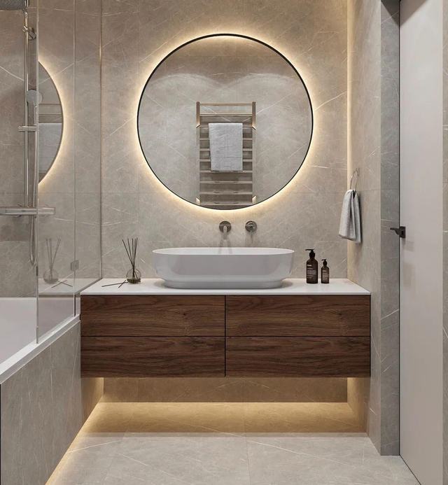 Walnut vanity with vessel basin and round lit mirror