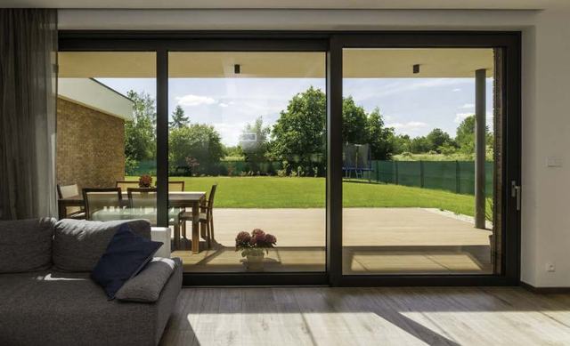 Wide sliding door opening a living room to the lawn